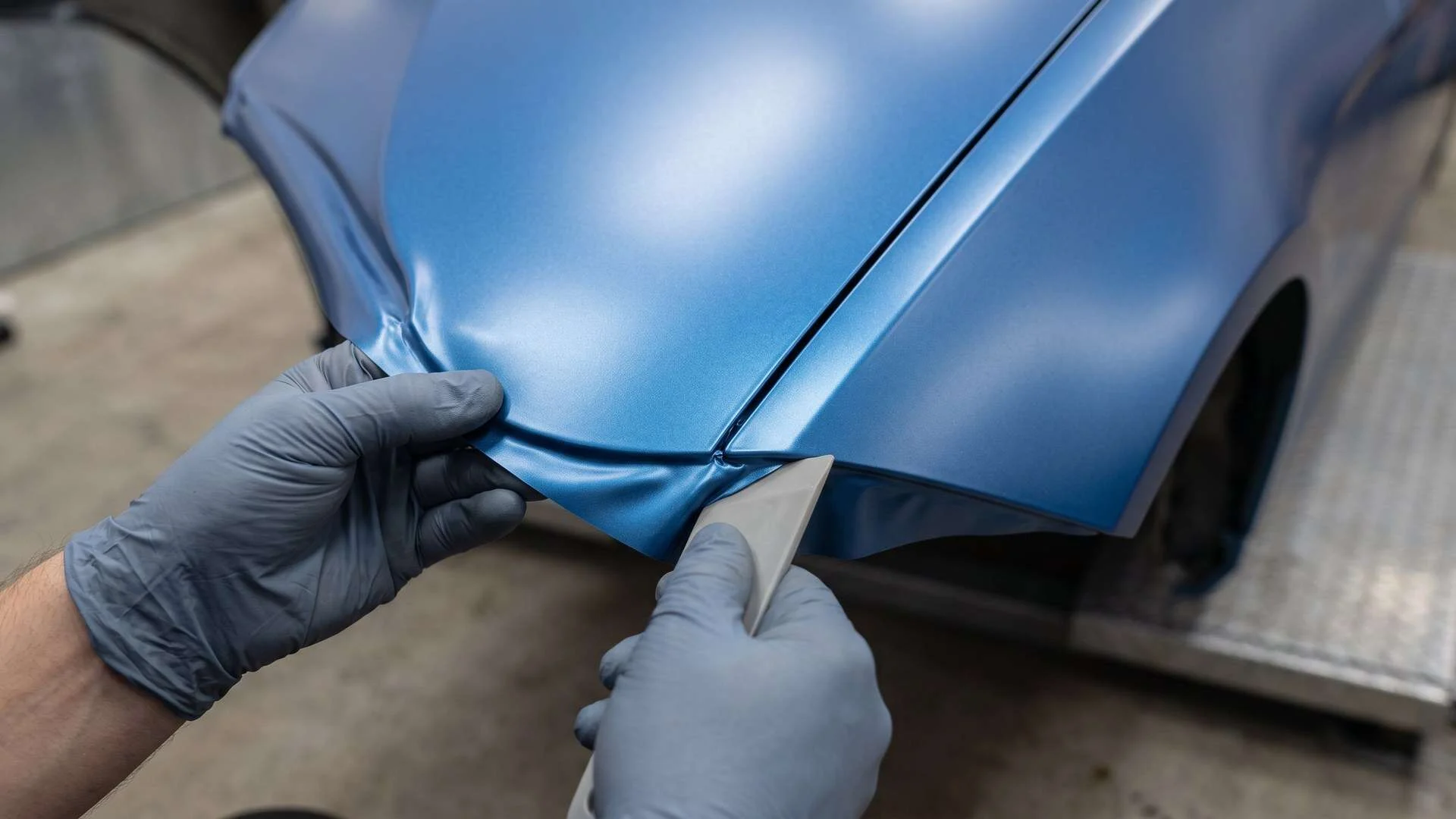 Close view of careful vinyl wrap finishing along a generic vehicle panel edge